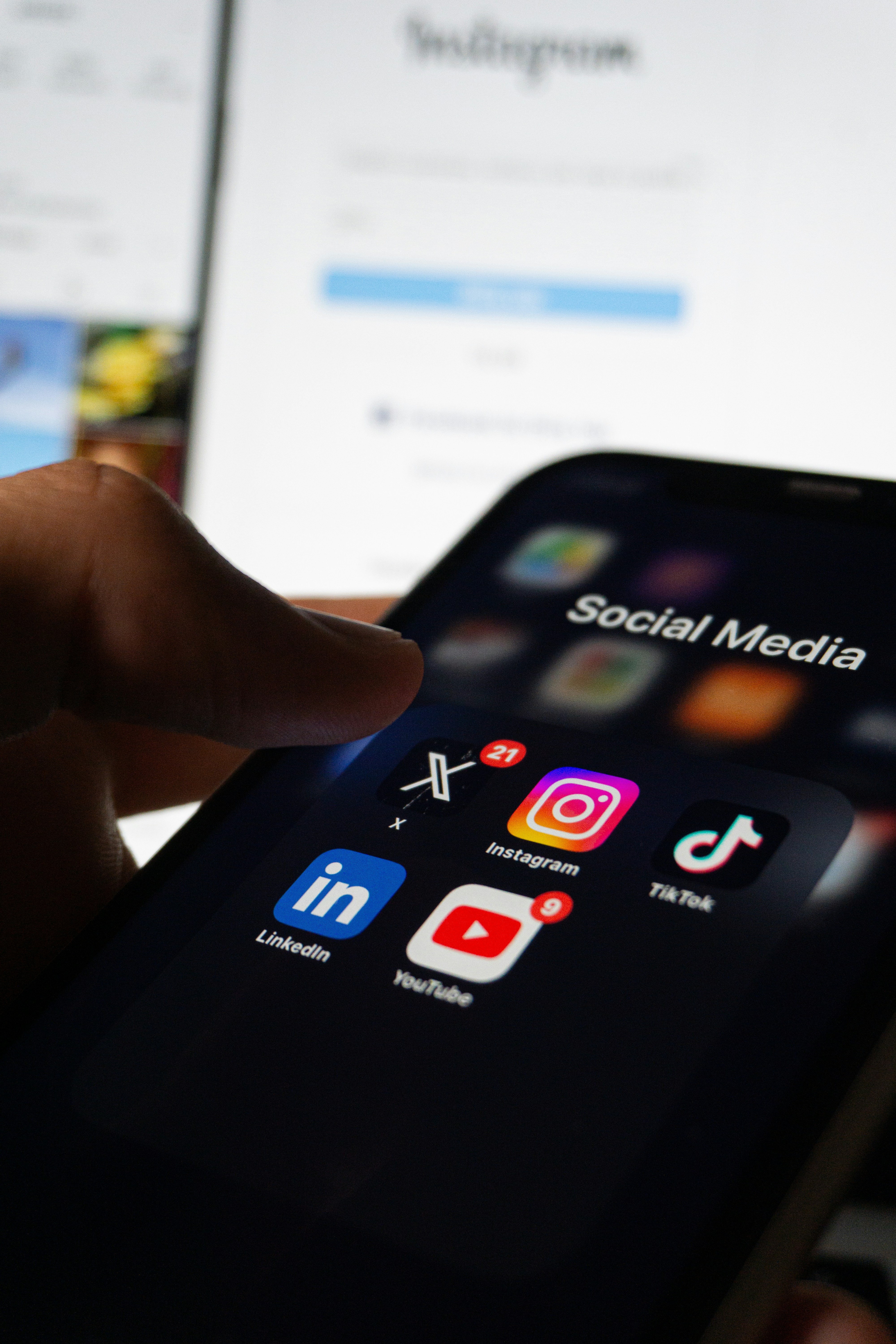 photo of a person holding their phone with a folder of social media apps