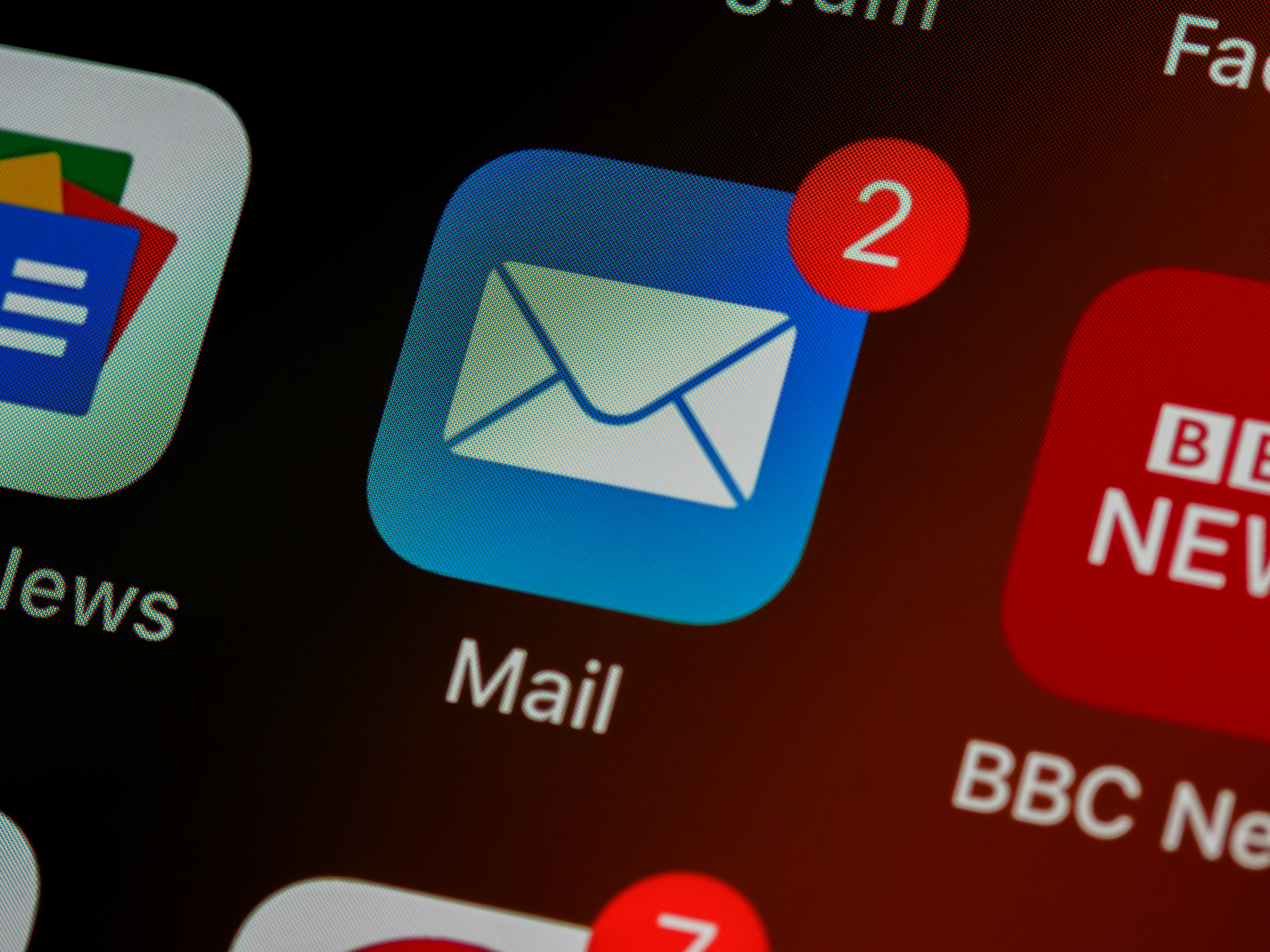 Close up of a phone screen, the Mail icon with a badge notification showing 2 notifications