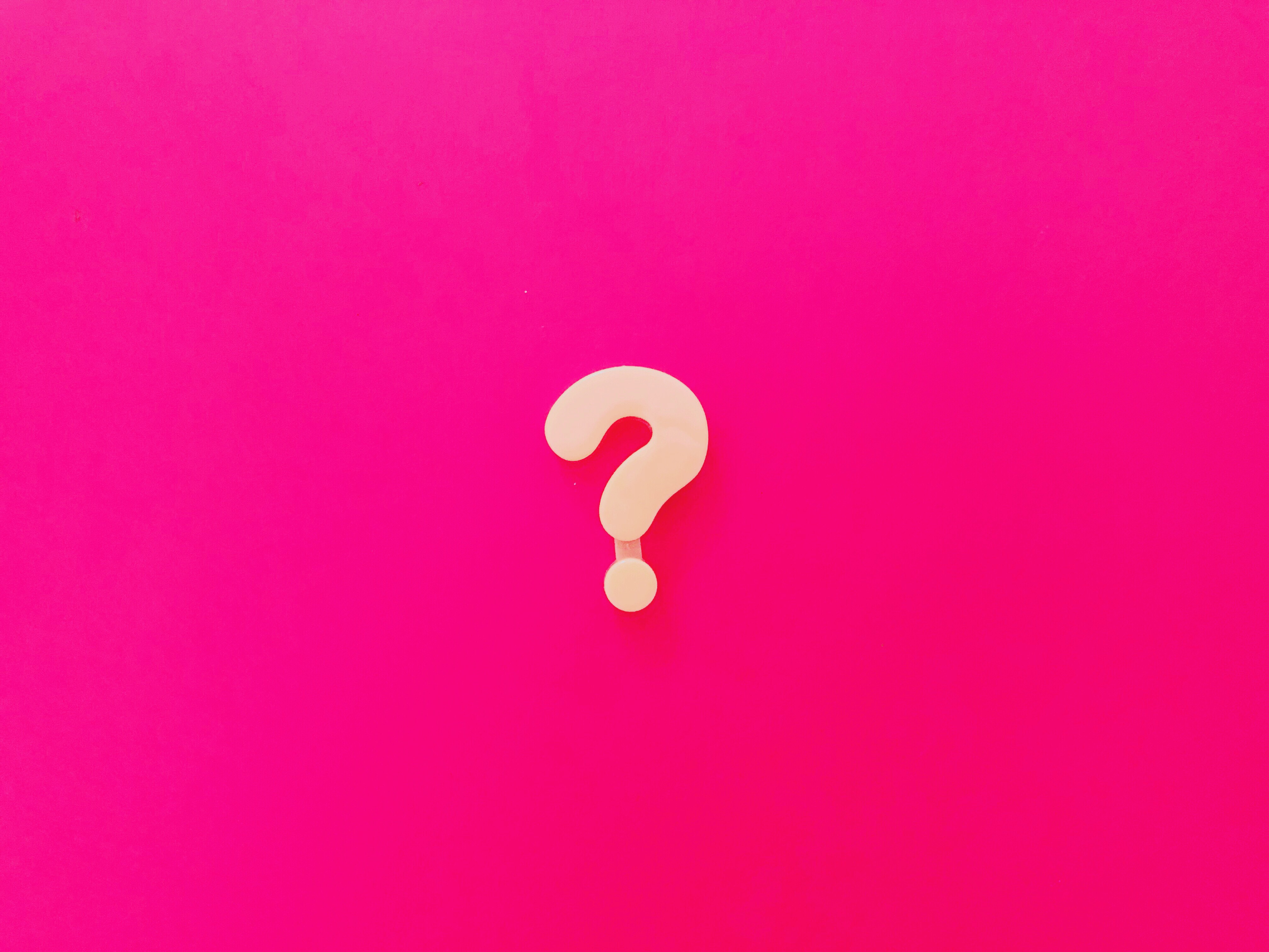 Hot pink background with a question mark in the centre