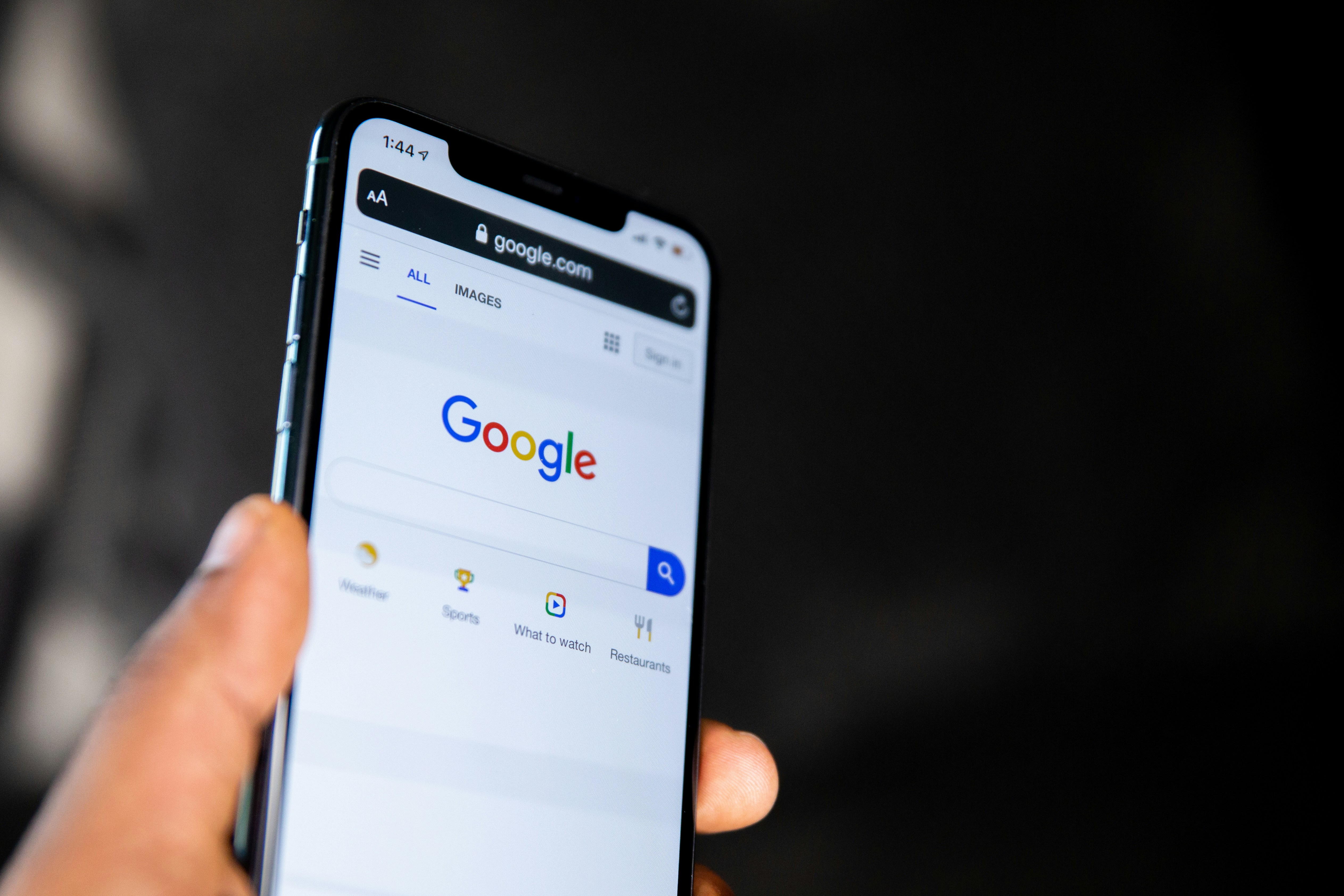 close up photo of a person holding their phone with the Google app open