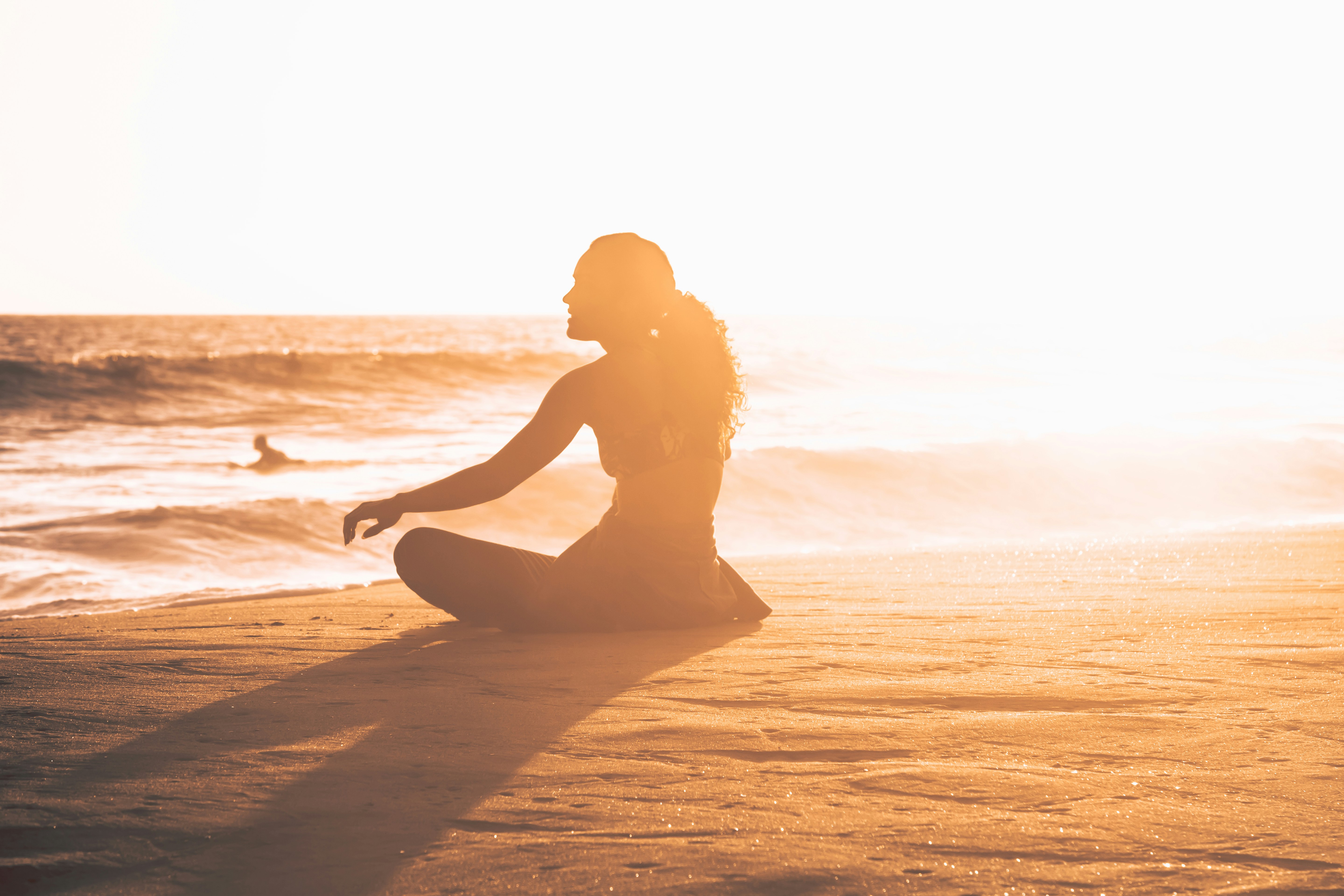person on a beach meditating