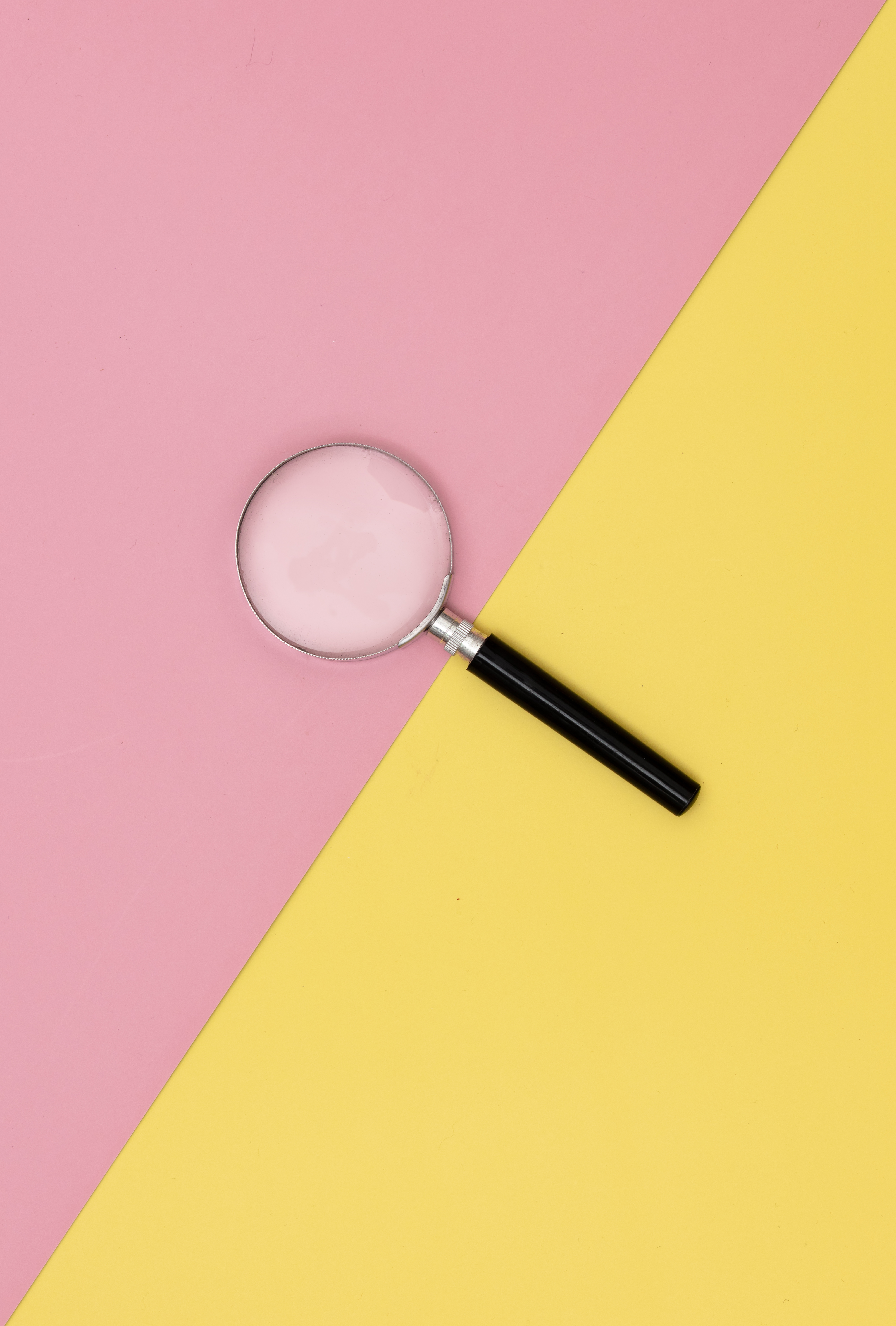 magnifying glass on pink and yellow background