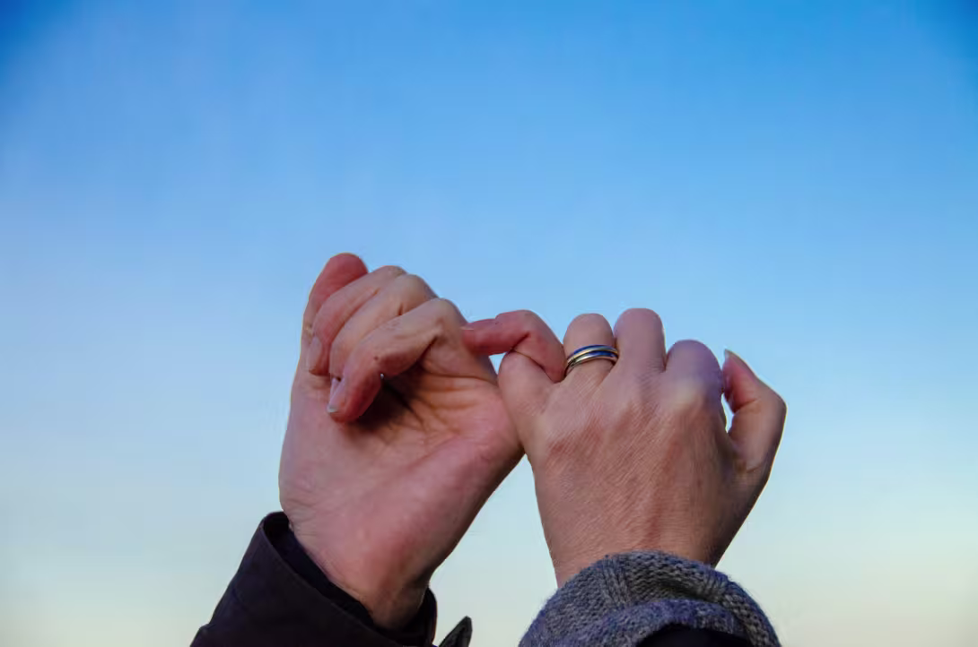 two hands linking little fingers together