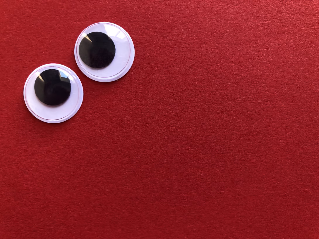 two googly eyes on a red background